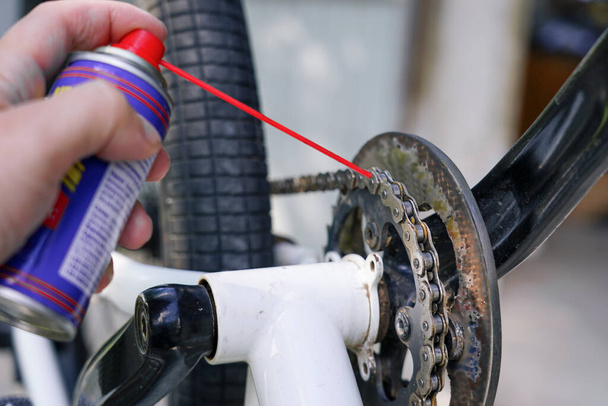 cara segurando lubrificante spray em sua mão para lubrificar o ch de bicicleta - Foto, Imagem