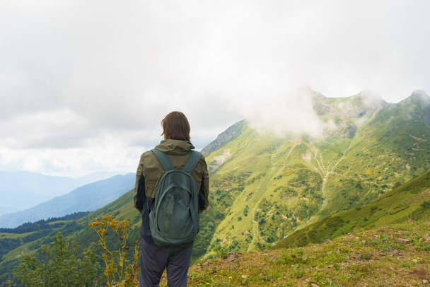 Νεαρός άνδρας στέκεται σε όμορφα βουνά για πεζοπορία. Ενεργό άτομο που αναπαύεται στη φύση. Backpacker κάμπινγκ εκτός αναψυχής ενεργό - Φωτογραφία, εικόνα