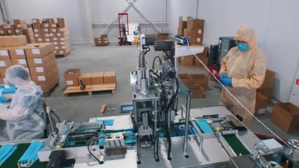 Przemysłowa produkcja niebieskich ochronnych masek medycznych za pomocą maszyny - Materiał filmowy, wideo