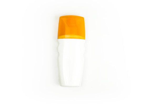 λευκό πλαστικό μπουκάλι σπρέι καλλυντικών, με πορτοκαλί καπάκι σε λευκό φόντο. Σπρέι για ήλιο - Φωτογραφία, εικόνα
