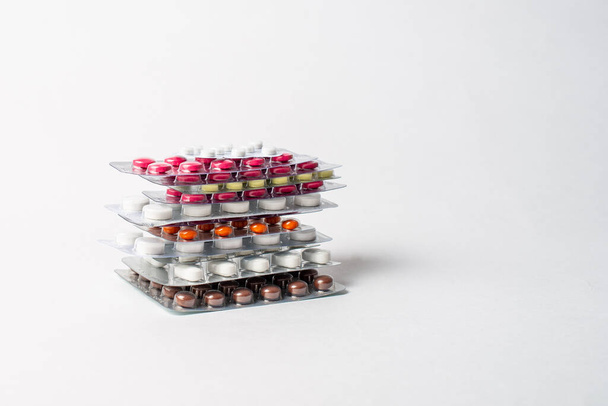 a stack of blisters with color pills on a white background - Φωτογραφία, εικόνα