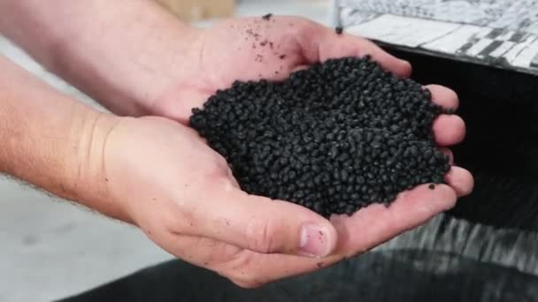 Férfi gazdaság műanyag fekete szürke granulált morzsa - Felvétel, videó