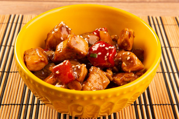 σκάκι κοτόπουλο σε κίτρινο μπολ σε ξύλινο φόντο - κινέζικο φαγητό. - Φωτογραφία, εικόνα