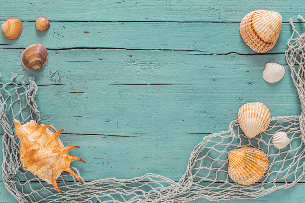 Sseashells and fishing net on old grey wooden background - Foto, afbeelding
