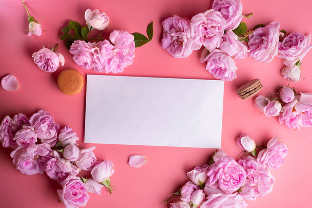 pink roses with white envelope and macaroons around pink background. life style concept - Foto, imagen