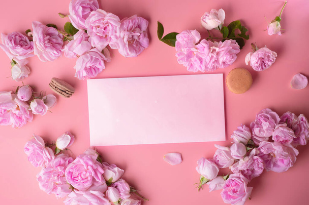 pink roses with white envelope and macaroons around pink background. life style concept - Foto, imagen