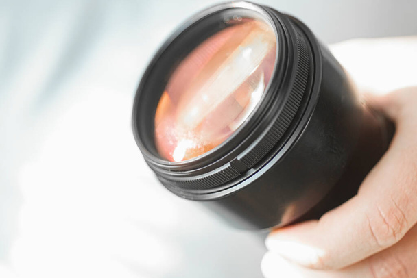 hand holds a dslr camera lens before service - Photo, Image