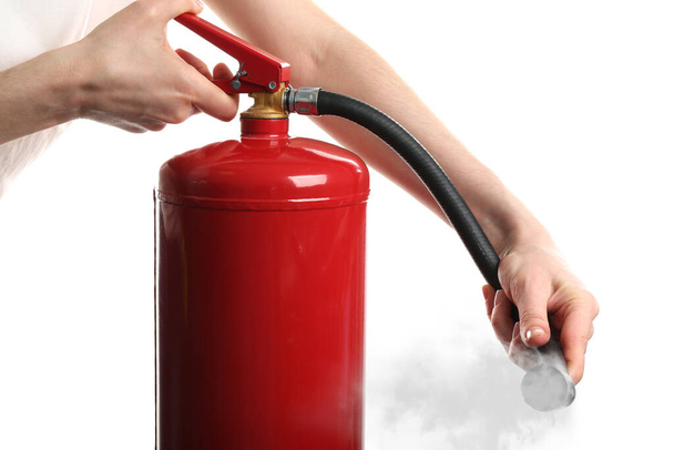 Woman using fire extinguisher on white background, closeup - Foto, Bild