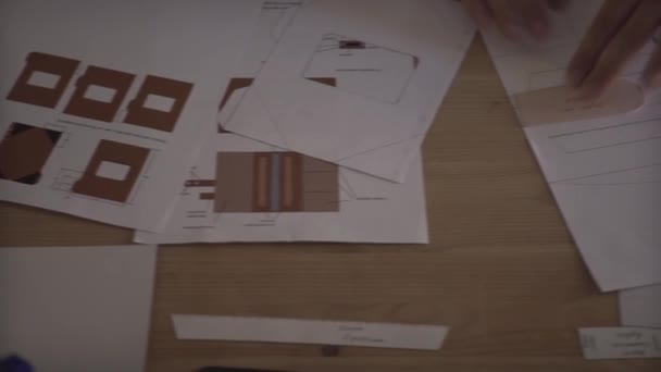 Muž ruku pečlivě pracuje se zaměřením na malé detaily podnikání projektu papírování na dřevěném stole - Záběry, video