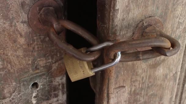 Puerta de madera antigua cerrada con candado rstico - Filmati, video