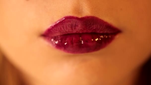 Houkutteleva naisen kielen nuolee hänen huulensa kirkkaan syvän punainen luumu marja kiiltävä huulipuna sävy huulikiilto lähikuva laukaus - Materiaali, video