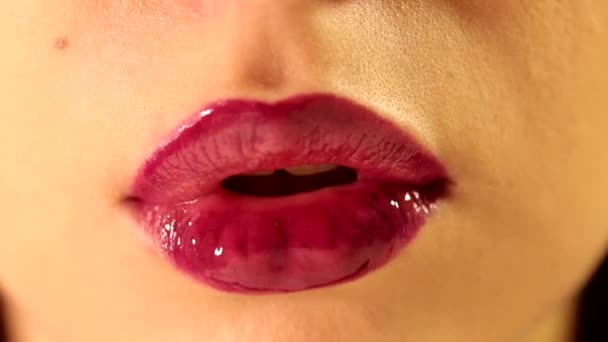 Close up tiro de bela língua feminina lambendo os lábios com brilhante profundo vermelho ameixa baga brilhante batom cor batom batom - Filmagem, Vídeo