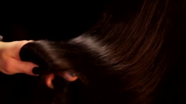 Close up černé pozadí záběr ženské ruky rotující krásné narovnané čokoládové brunetky tmavé barvy lesklé vlasy - Záběry, video