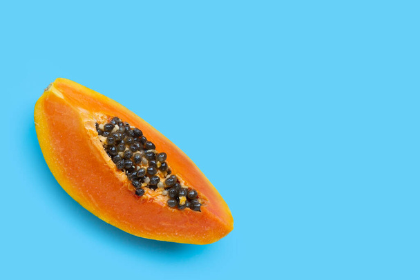 Papaya fruit on blue background. Top view - 写真・画像