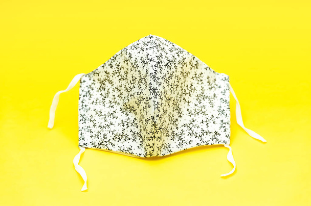 Охорона здоров'я - Квітковий візерунок (білий і чорний колір) Обличчя тканини DIY маска для захисту від Коронавірусу (COVID-19) та інших інфекційних захворювань. Розташований на жовтому тлі. Підсумок..  - Фото, зображення