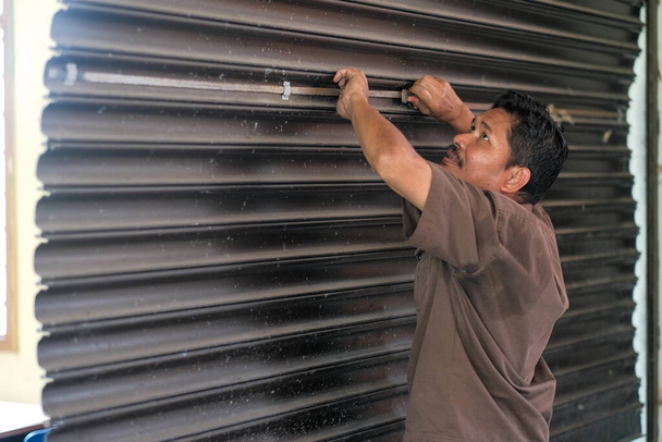 The  contractor is making reparation of rolling shutter in classroom - Photo, Image