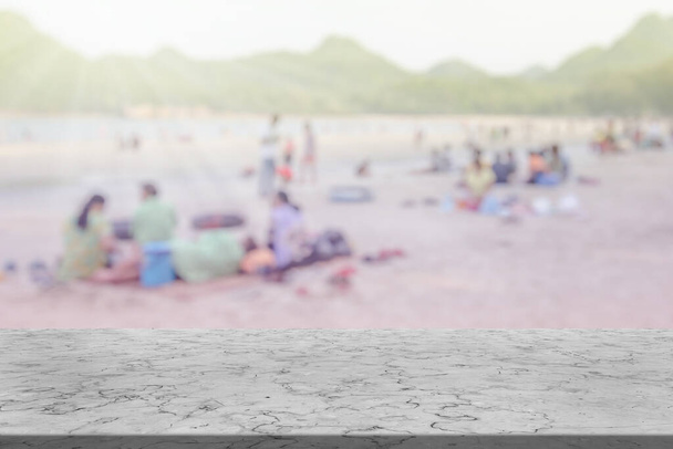 Mramorový stůl s mnoha lidmi na pláži rozmazané pozadí - Fotografie, Obrázek