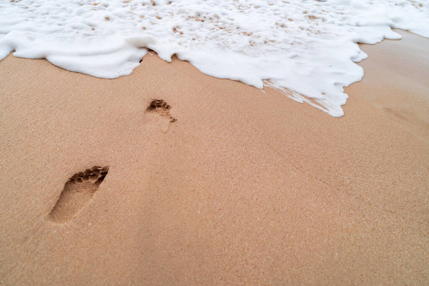 Ludzki ślad na piasku letnie tropikalne tło plaży z przestrzenią do kopiowania. - Zdjęcie, obraz