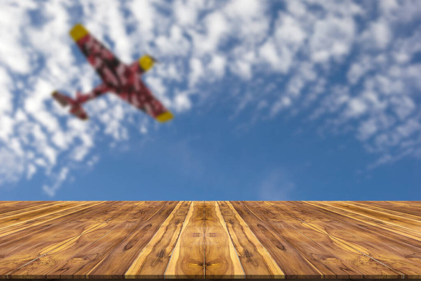 Ξύλινο τραπέζι με θολό ουρανό και φόντο αεροπλάνο - Φωτογραφία, εικόνα