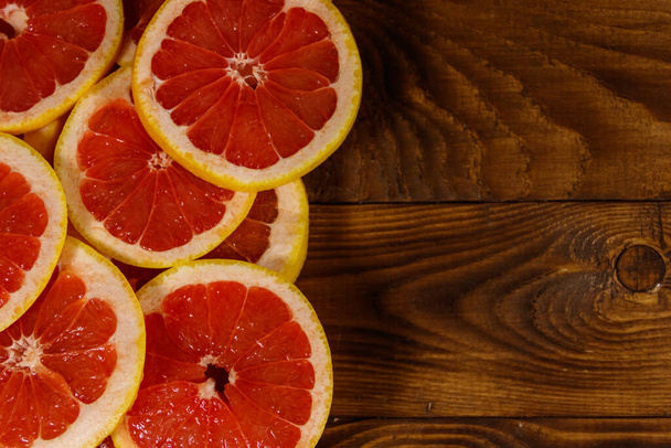 Sliced grapefruits on wooden table. Top view, copy space - Foto, immagini