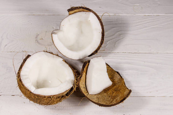 Fresh ripe coconut on white wooden table. Top view - Valokuva, kuva
