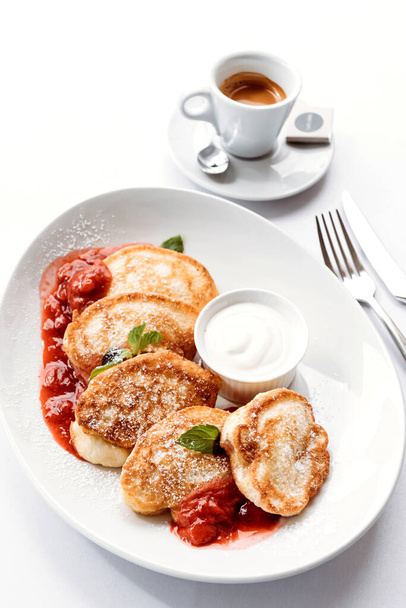 Breakfast in cafe, pancakes on white plate with espresso. - Фото, изображение