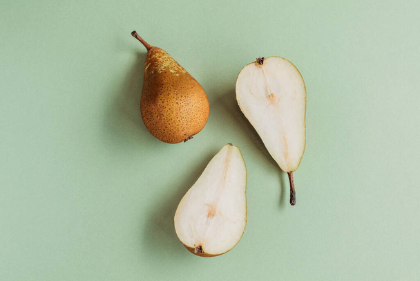 Cut pears on green background top view. - Fotó, kép