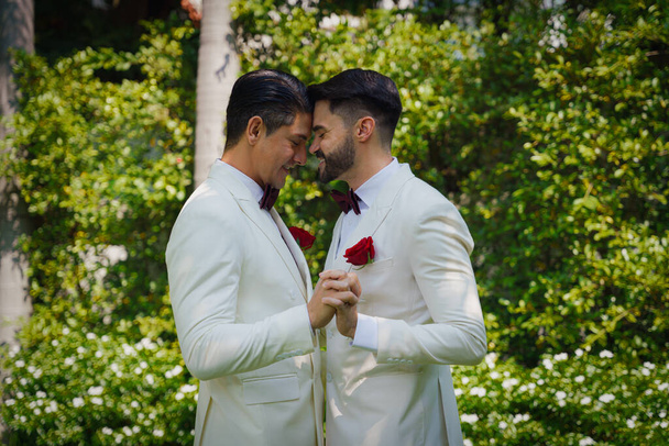 gay bride and groom in white suit happy together in LBGT wedding ceremony - Foto, immagini