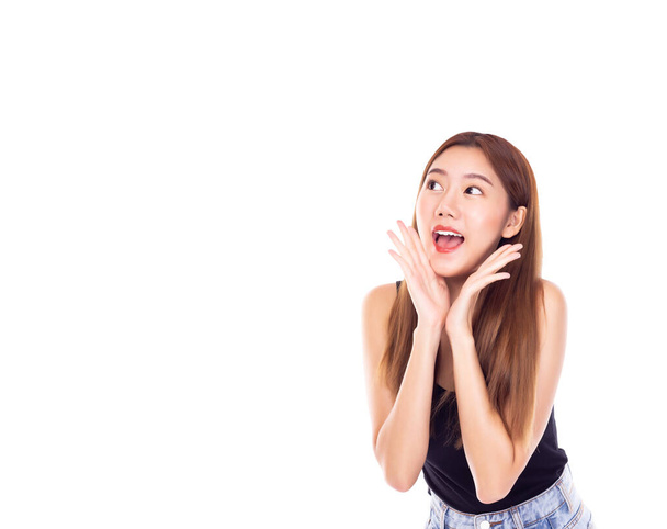 Beautiful young asian female act like an announce to someone or Pretty women telling or promoting something and look at copy space. She get happy excited woman with open mouth keeping hand at face - Photo, Image