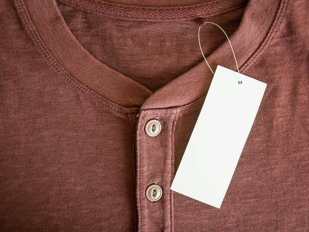 nueva camisa marrón con etiqueta de precio en blanco - Foto, imagen