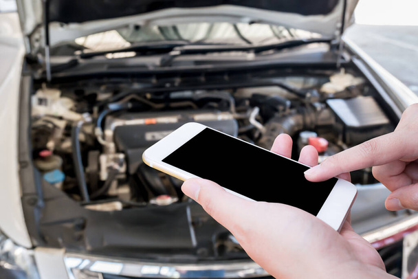 woman using mobile smart phone with broken down car background, emergency service concept - Photo, image