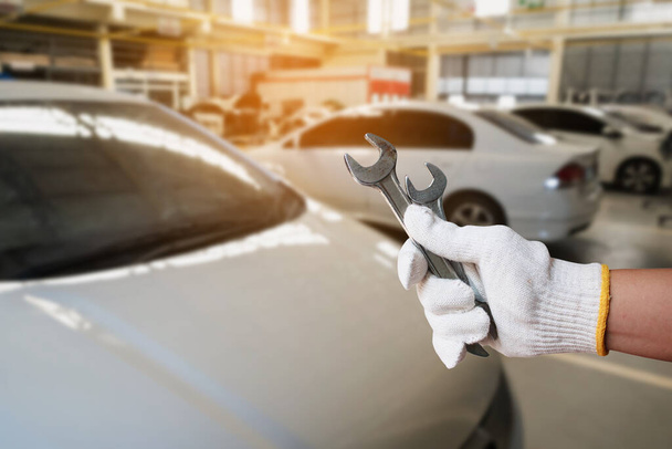 Automaattinen mekaanikko käsi tilalla jakoavain yli auton korjaus huoltokeskuksen autotalli - Valokuva, kuva