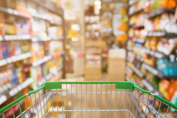 Carrito de compras con Abstract Supermarket aisle blur background - Foto, Imagen