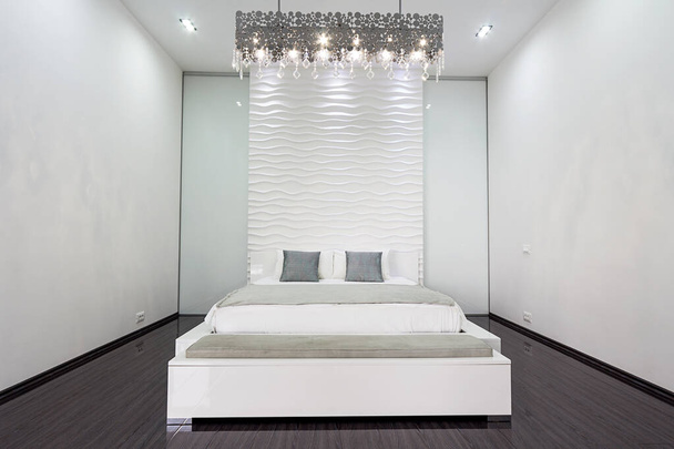 nowoczesne mieszkanie w jasnych kolorach. sypialnia z dużym białym łóżkiem i ciemnym parkietem Paryż czerwiec 2020 - Zdjęcie, obraz