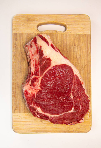 Raw T Bone steak on wooden board prepared to Grill  - Foto, afbeelding