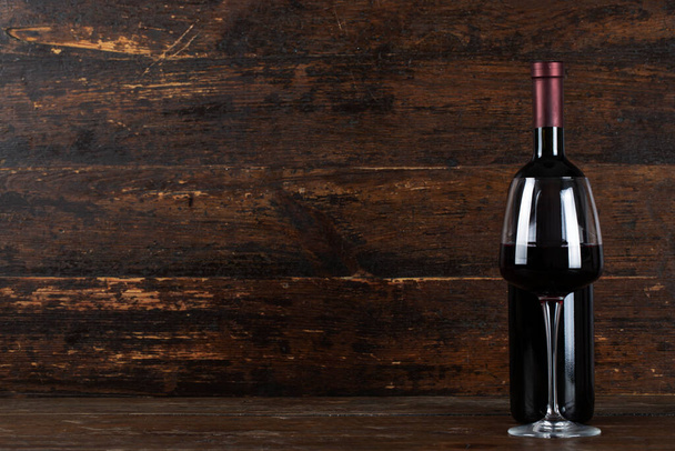 Wine bottle and glass on wooden background - Zdjęcie, obraz