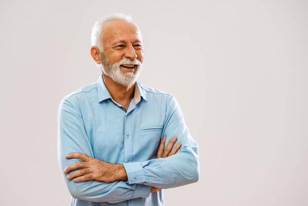 Portret van een vrolijke oudere man die wegkijkt en glimlacht. - Foto, afbeelding