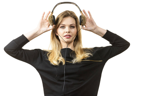 Teenager young grunge woman wearing black and listening to music on headphones with spikes - Foto, imagen