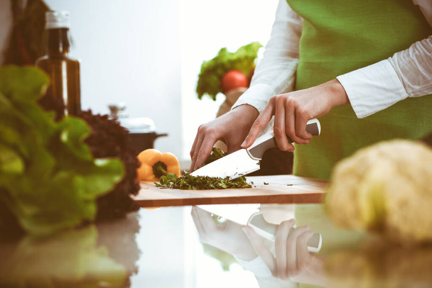 Nieznane ludzkie dłonie gotują w kuchni. Kobieta jest zajęta sałatką warzywną. Zdrowy posiłek i koncepcja wegetariańskiej żywności - Zdjęcie, obraz