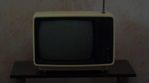 Ретро советский портативный аналоговый телевизор на маленьком столе в сумерках - Кадры, видео