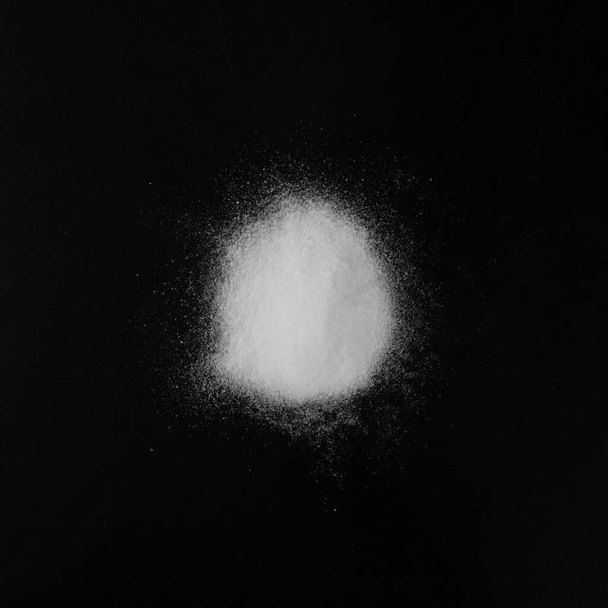 Un mucchio di polvere bianca di bicarbonato di sodio, argilla o Bentonite su sfondo nero. Prodotti chimici in polvere come calcio, gesso o gesso Vista dall'alto - Foto, immagini