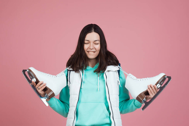Figure skating for adults, Hobbies and a healthy lifestyle. A young woman in a bright sweatshirt with figure skates - Zdjęcie, obraz