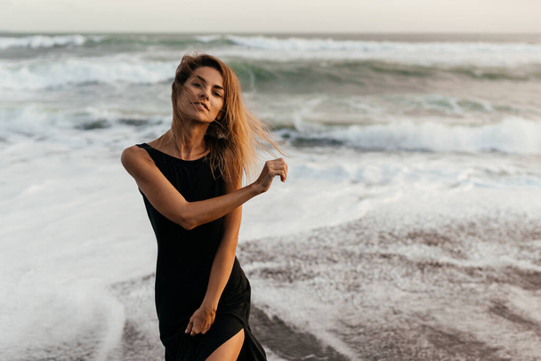 woman on beach is enjoying serene ocean nature during travel holidays vacation outdoors - Fotografie, Obrázek