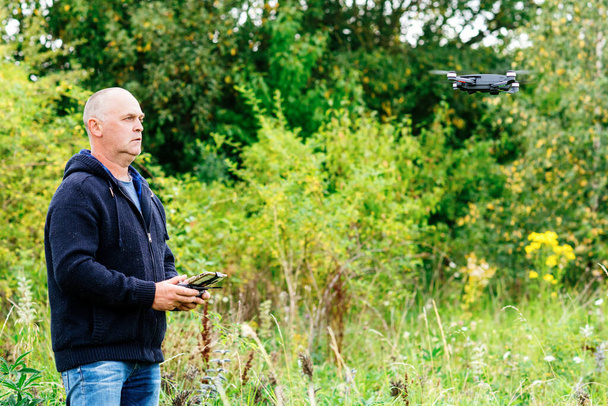 un hombre lanzando un dron en un prado - Foto, Imagen