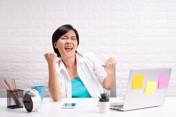 Feliz mulher bem sucedida com as mãos levantadas sentado em casa escritório trabalhando usando laptop de computador - Foto, Imagem
