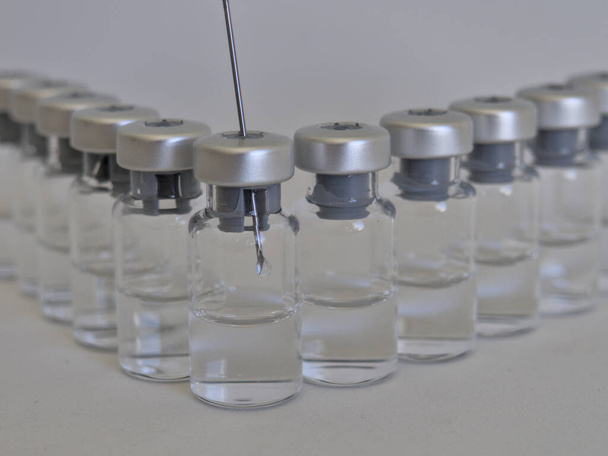 Вакцинаційні пляшки та шприц з ін'єкційною рідиною та алюмінієвими кришками
 - Фото, зображення