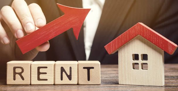 Wooden blocks with the word Rent, house and up arrow. The concept of the high cost of rent for an apartment or home. Interest rates are rising. Real estate market. Increased demand for rental property - Photo, image