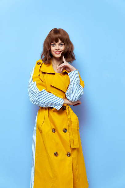 Happy woman makeup brunette yellow coat with buttons. - Фото, изображение