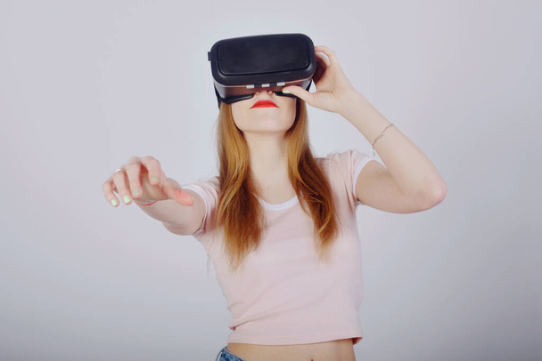 Girl on a white background plays virtual reality. Games and films vr. Emotions - Foto, immagini