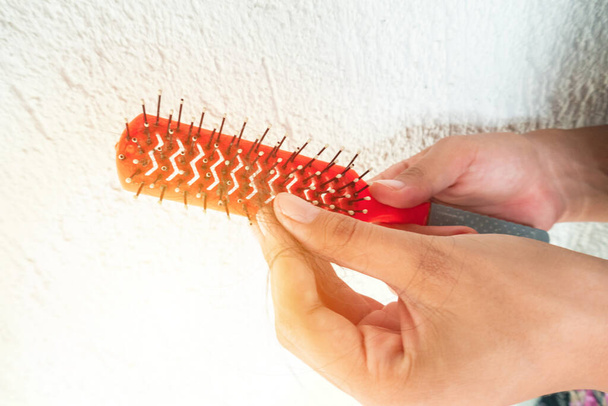 mujer quita el cabello de un cepillo de peinado - Foto, imagen